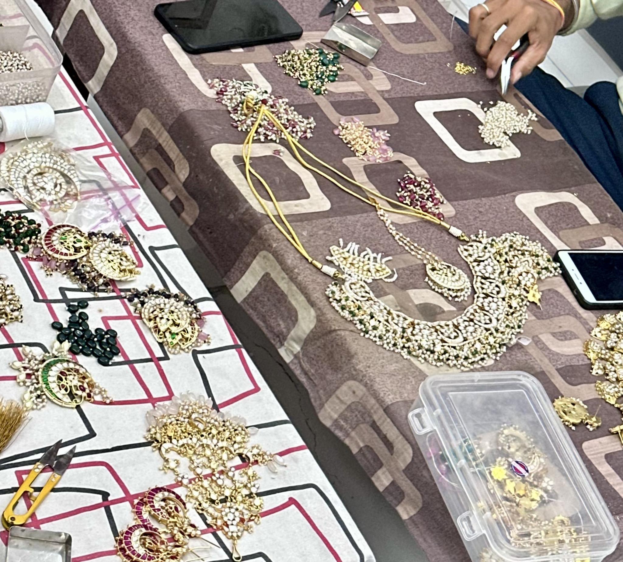 Beads, pearls and a kundan necklace being reworked on the bench